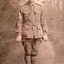 Sepia photograph of William Edward Peach,  a WWI soldier in uniform holding a crop across his thighs.