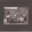 Framed photograph depicting a group of school girls and teachers posing outside a brick school building