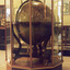 Large wooden globe of the world encased in a glass and wood display case.