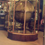 Large wooden globe of the world from the opposite perspective, encased in a large wood and glass display case. The photo is on a slight angle.