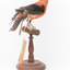 Taxidermy specimen of a male Scarlet Tanager standing on a wooden mount.