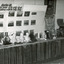Black and white photograph of museum collection featuring busts, a photo display and other objects