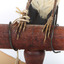 White Winged Triller standing on wooden mounted post facing forward, close-up of feet. 