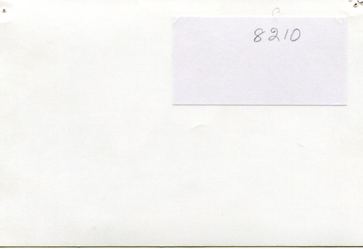 Reverse of photograph with written number stuck on a separate white paper