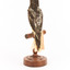 A Regent Honeyeater standing on a wooden mount facing back