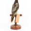 A Regent Honeyeater standing on a wooden mount facing back