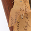 Image of torn paper swing tag with a second swing tag underneath, text on torn swing tag is illegible.
