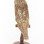 Barking Owl standing on wooden pedestal mount facing back.