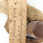 Masked Owl mounted on wooden perch pedestal with swing tag. Close-up view of paper swing tag attached to lower leg (see inscription).