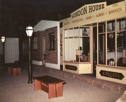 Colour photograph of indoor museum display showing recreated heritage street scene with shopfronts, lamp posts and benches