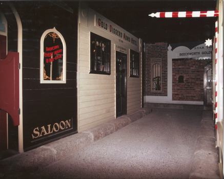 Colour photograph contains the frontage and display of shops, mainly a saloon and 'Gold Diggers Arms Hotel'.