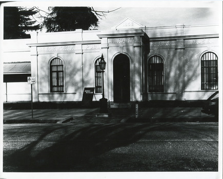 Black and white photograph of the front of the Burke Museum, with a sign out the front.