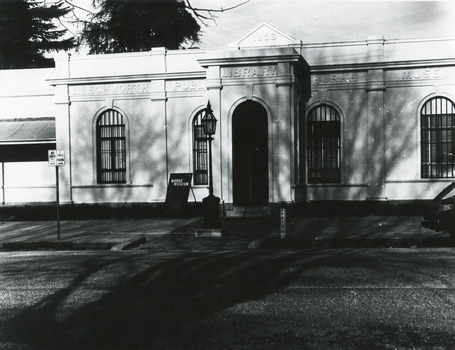 Black and white photograph of the front of the Burke Museum, with a sign out the front.