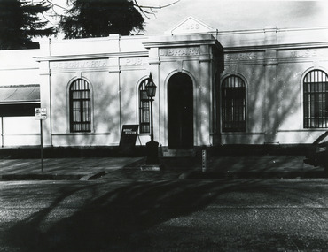 Black and white photograph of the front of the Burke Museum, with a sign out the front.