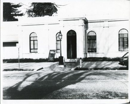 Black and white photograph of the front of the Burke Museum, with a sign out the front.
