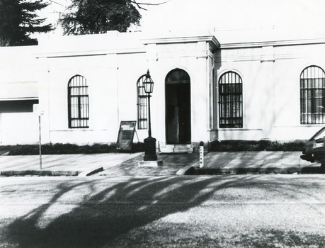 Black and white photograph of the front of the Burke Museum, with a sign out the front.