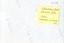 The mostly blank reverse of a photograph with the AFGA logo at regular intervals and the photo's identification number in the top right corner. A yellow sticky note is attached underneath the identifcation number with handwritten text (see transcription).