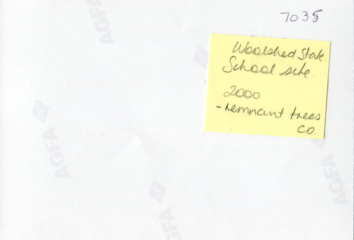 The mostly blank reverse of a photograph with the AFGA logo at regular intervals and the photo's identification number in the top right corner. A yellow sticky note is attached underneath the identifcation number with handwritten text (see transcription).