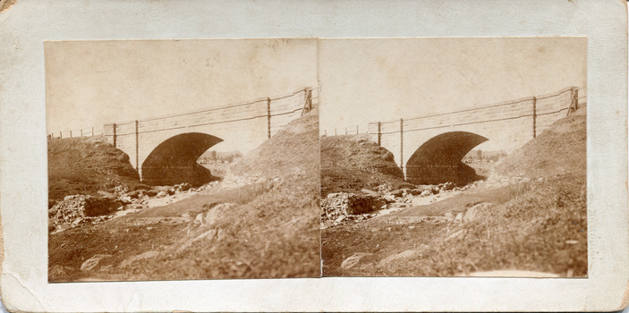 Two sepia-toned photographs featuring a bridge in the background on card
