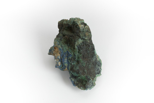 A hand-sized solid mineral specimen in shades of blue, green, and yellow