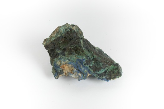 A hand-sized solid mineral specimen in shades of blue, green, and yellow