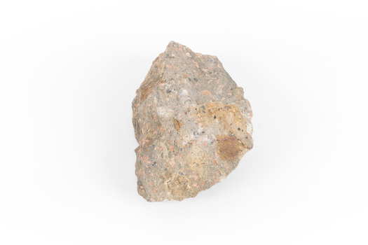 A solid, dark grey mineral specimen with pale terracotta coloured inclusions