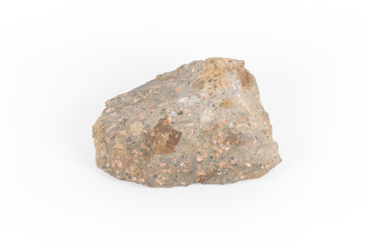 A solid, dark grey mineral specimen with pale terracotta coloured inclusions