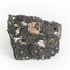 A smaller than hand sized rock specimen which is dark grey in colour with small holes and white deposits across its surface.