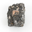 A smaller than hand sized rock specimen which is dark grey in colour with small holes and white deposits across its surface.