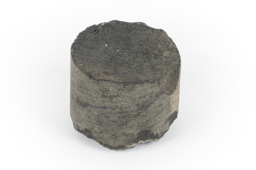A small cylinder shaped piece of Basalt with smooth sides and broken top and bottom edges.