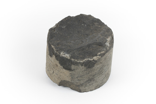 A small cylinder shaped piece of Basalt with smooth sides and broken top and bottom edges.