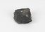 A dark coloured geological specimen with some brown and blue colouration. The shape is roughly triangular, featuring some straight edges and overall geometric shape. The number 53 is adhered to the top surface, a reference to the original catalogue