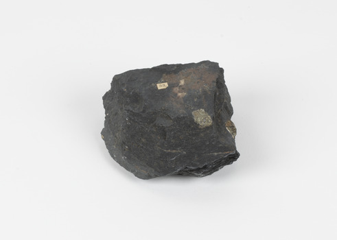 A dark coloured geological specimen with some brown and blue colouration. The shape is roughly triangular, featuring some straight edges and overall geometric shape. The number 53 is adhered to the top surface, a reference to the original catalogue