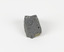 An angular, hand sized grey geological specimen in white spotted grey colours, with one flat brown side.
