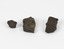 Three block pieces of dark chocolate, light brown and grey organic matter sitting on a white surface. 