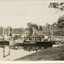 Type of boat, called a punt, docked at pier on a riverbank