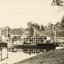 Type of boat, called a punt, docked at pier on a riverbank