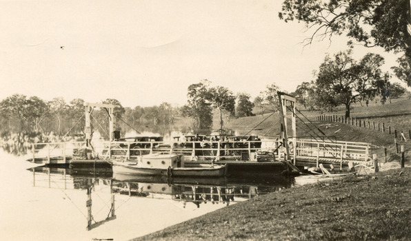 Type of boat, called a punt, docked at pier on a riverbank