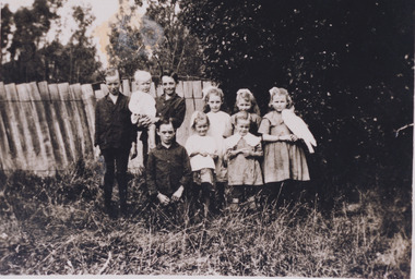 Image of Evelyn Jensen with five other girls and three boys. A white bird is perched on one of girl's arms. This image is for the Jennifer Williams Oral History Project