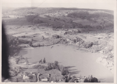 Black and white aerial photograph of a lake and surrounding landscape.