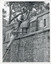 View of outside wall of Powder Magazine Beechworth with a group of workmen at the top and single man poised on a ladder leaning against the wall.