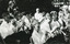 Black and white photograph depicting a band playing various types of instruments. All band members are dressed in formal attire.