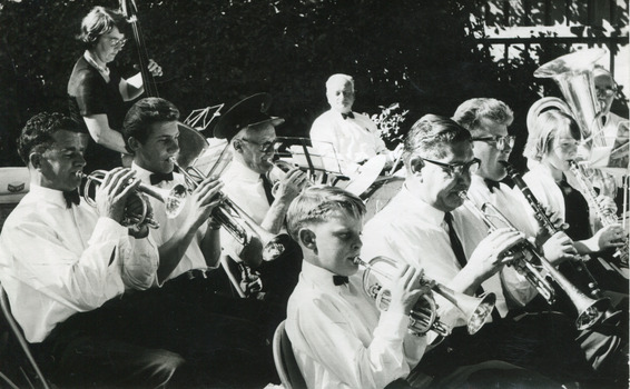 Black and white photograph depicting a band playing various types of instruments. All band members are dressed in formal attire.