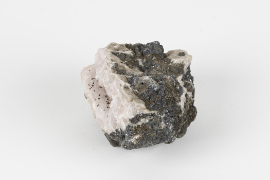 Hand-sized piece of pale pink mineral specimen with dark grey rim and hollowed centre. 