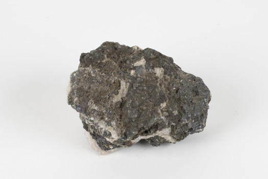 Hand-sized piece of pale pink mineral specimen with dark grey rim and hollowed centre. 