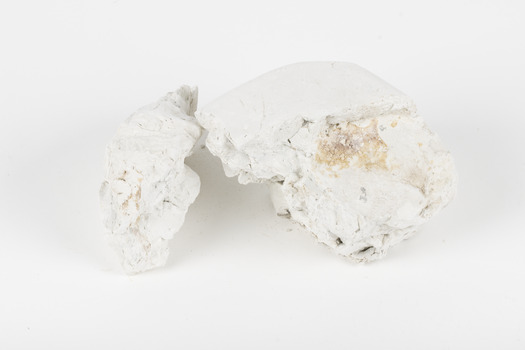 Two hand-sized solid mineral specimen in shades of white and gray 