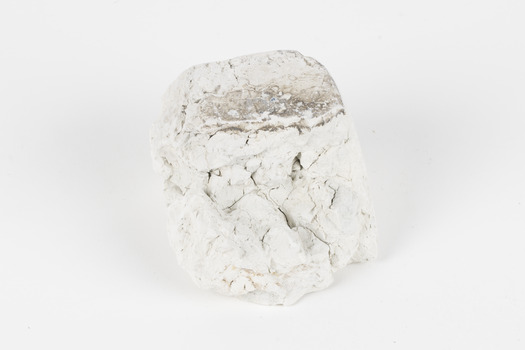 Hand-sized solid mineral specimen in shades of white and gray 