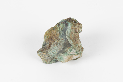 Small mineral specimen in shades of white, green, orange and gray