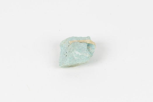 A palm-sized mineral specimen in shades of blue-green with white veining.