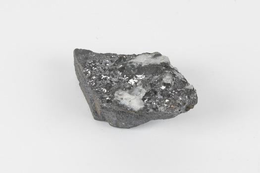 A flat hand-sized grey mineral specimen with translucent white crystallised formation on top. 